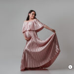 Vestido largo, de corte con imperio amplia plisada; escote off-shoulder con volante que aporta movimiento y elegancia de color rosa palo